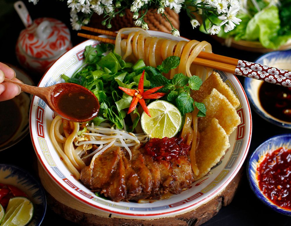 Traditionelles Cao-Lầu-Nudelgericht mit Kräutern und knusprigen Zutaten in Hoi An