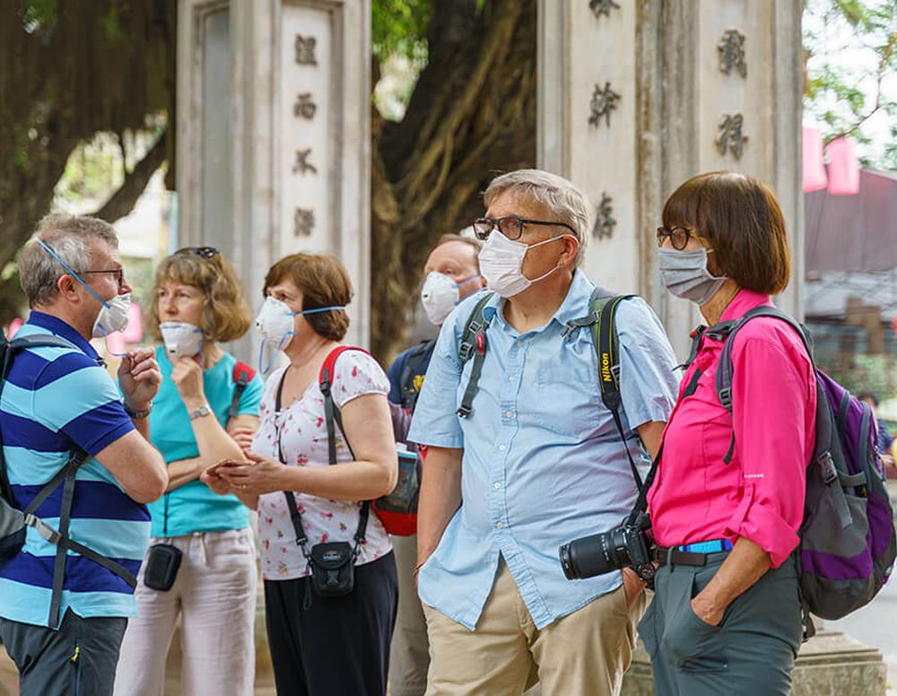 Touristen tragen die Masken i n Vietnam 