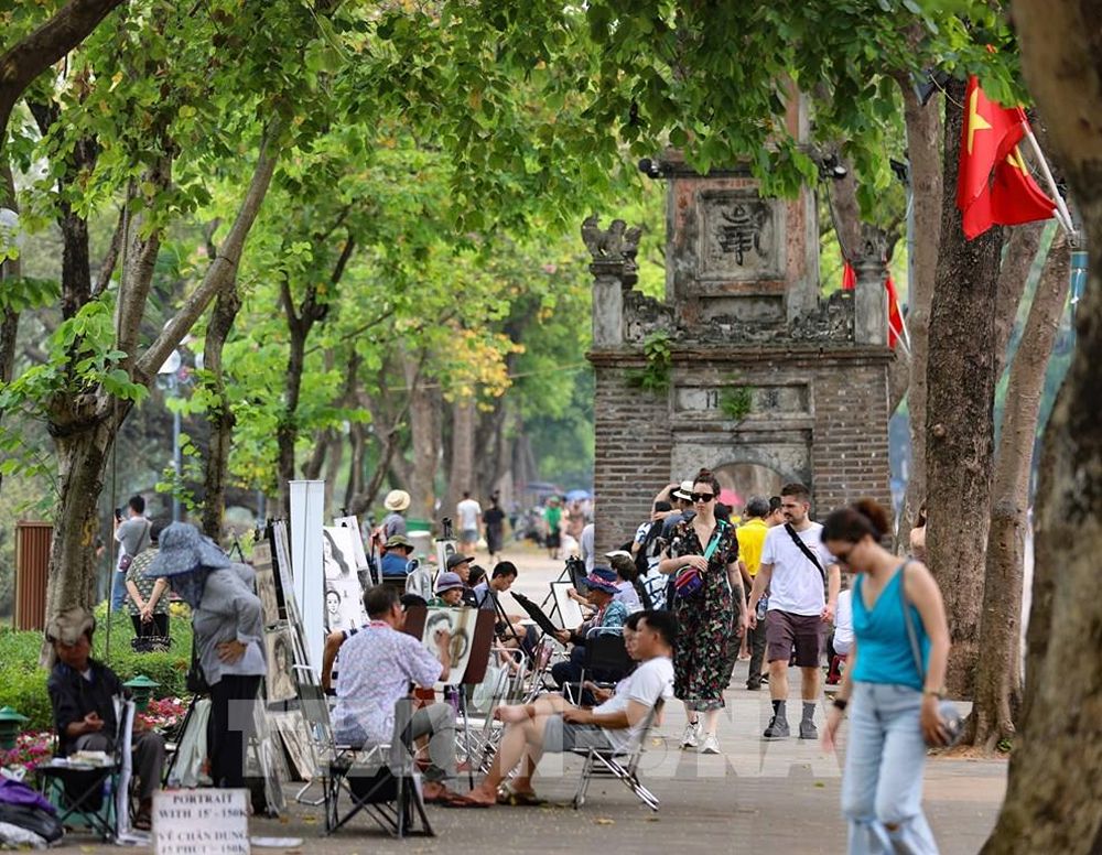 Spaziergang am Hoàn-Kiếm-See in Hanoi mit Blick auf den See und die grüne Uferpromenade.